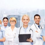 smiling female doctors and nurses with stethoscope