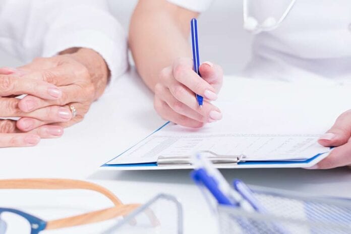 Closeup of nurses interviewing someone with clipboard