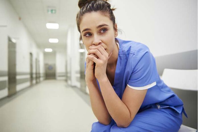 Female nurse sitting and wondering how to deal with the feelings of burnout