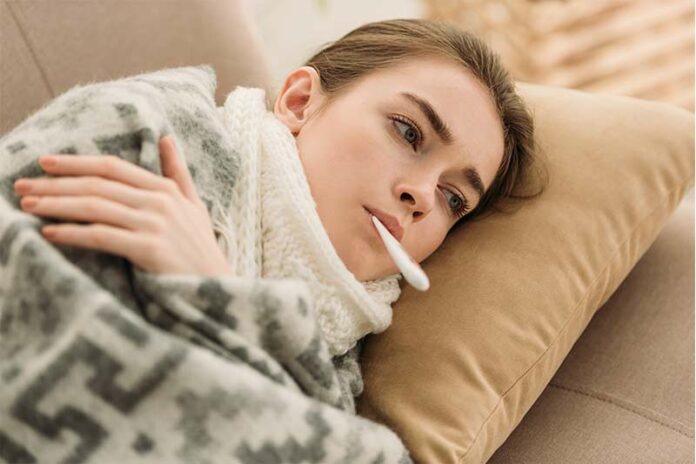 Woman wishing she hadn't gotten sick on the couch