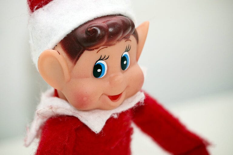 Close-up of elf on the shelf sitting against white background