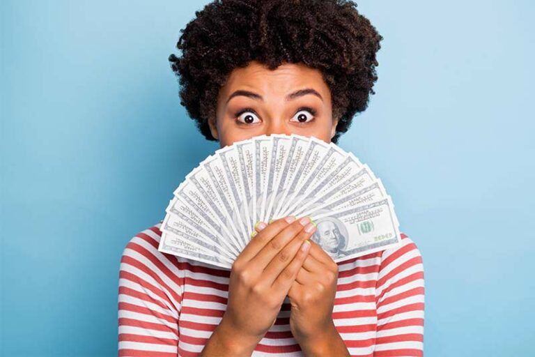 African American woman holding money wondering how to spend it