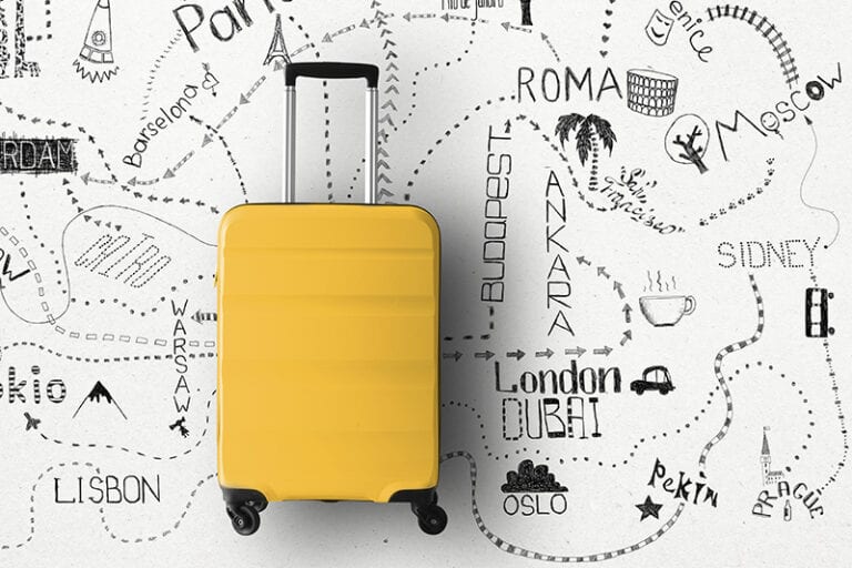Yellow suitcase laying on hand drawn map of travel destinations